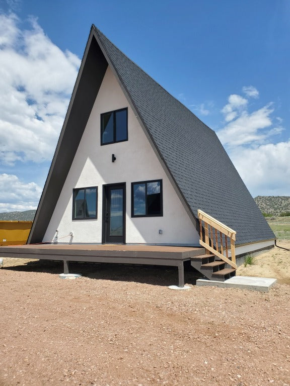 Vega A-frame cabin with charcoal siding and wood deck at Observer Ranch