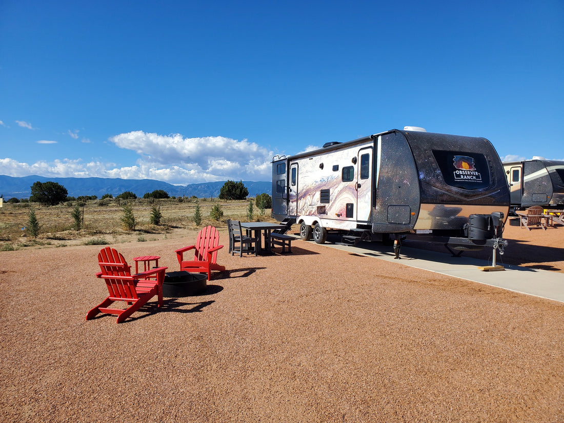 Jupiter planet camper with red Adirondack chairs and fire ring at Observer Ranch