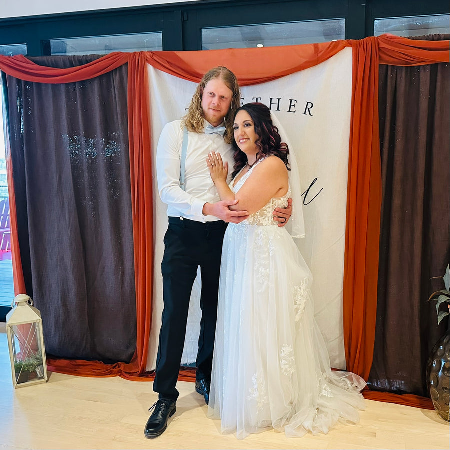 Bride and groom embracing at the draped backdrop, Observer Ranch Penrose Colorado