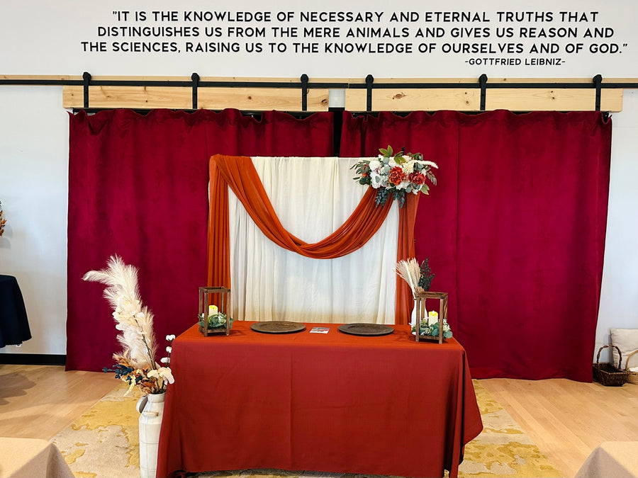 Burgundy wedding ceremony backdrop with floral arch at Observer Ranch, Penrose Colorado