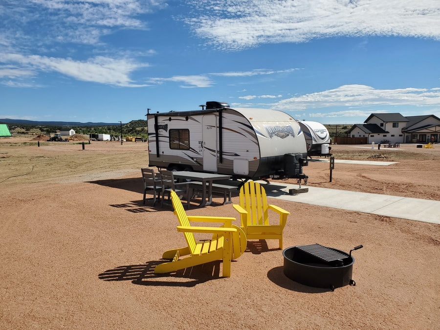 Orion planet camper with yellow Adirondack chairs and fire pit at Observer Ranch