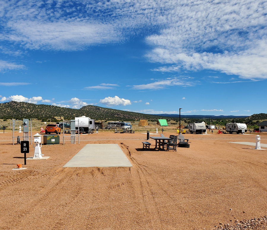 Signature pull-through RV site 21 with concrete pad and full-hookup utility pedestal at Observer Ranch