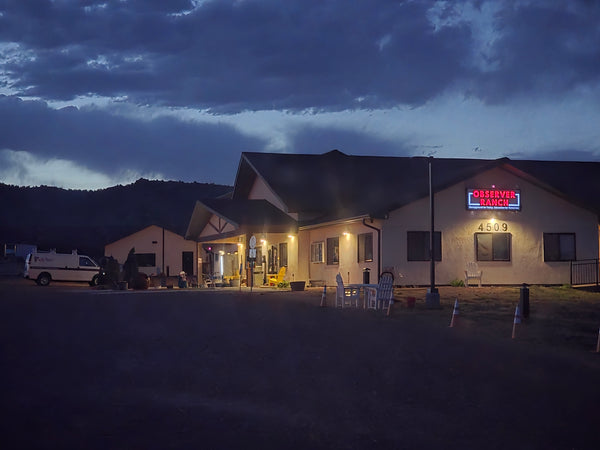 Observer Ranch lodge exterior at night with lit sign