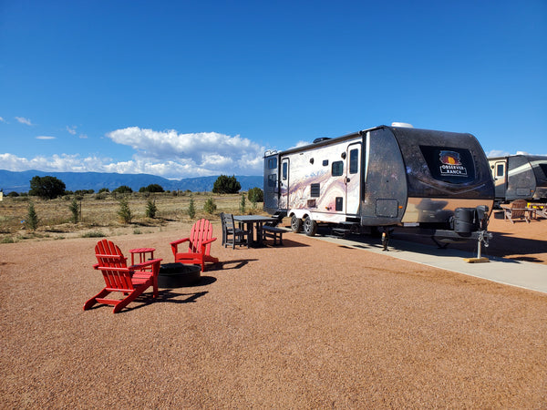 Jupiter planet camper wrap exterior with red Adirondack chairs and fire ring