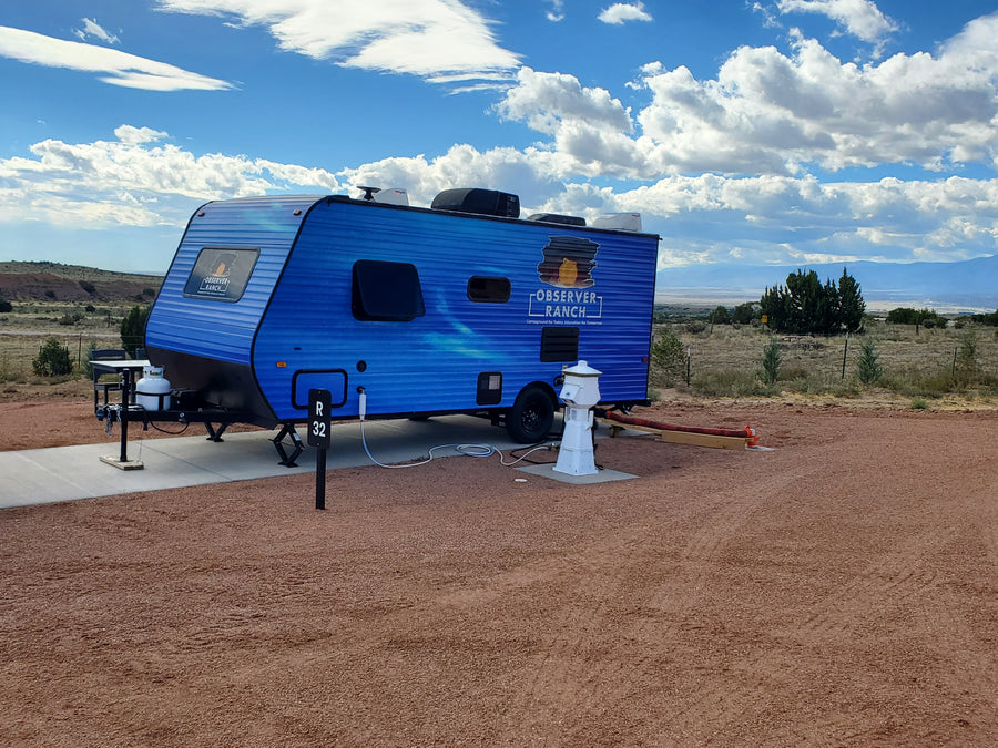 Neptune planet camper with blue aurora vinyl wrap exterior at RV site